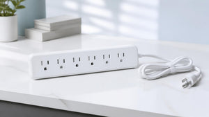 White multi-outlet surge protector power strip on a clean desk | Conversions Tech